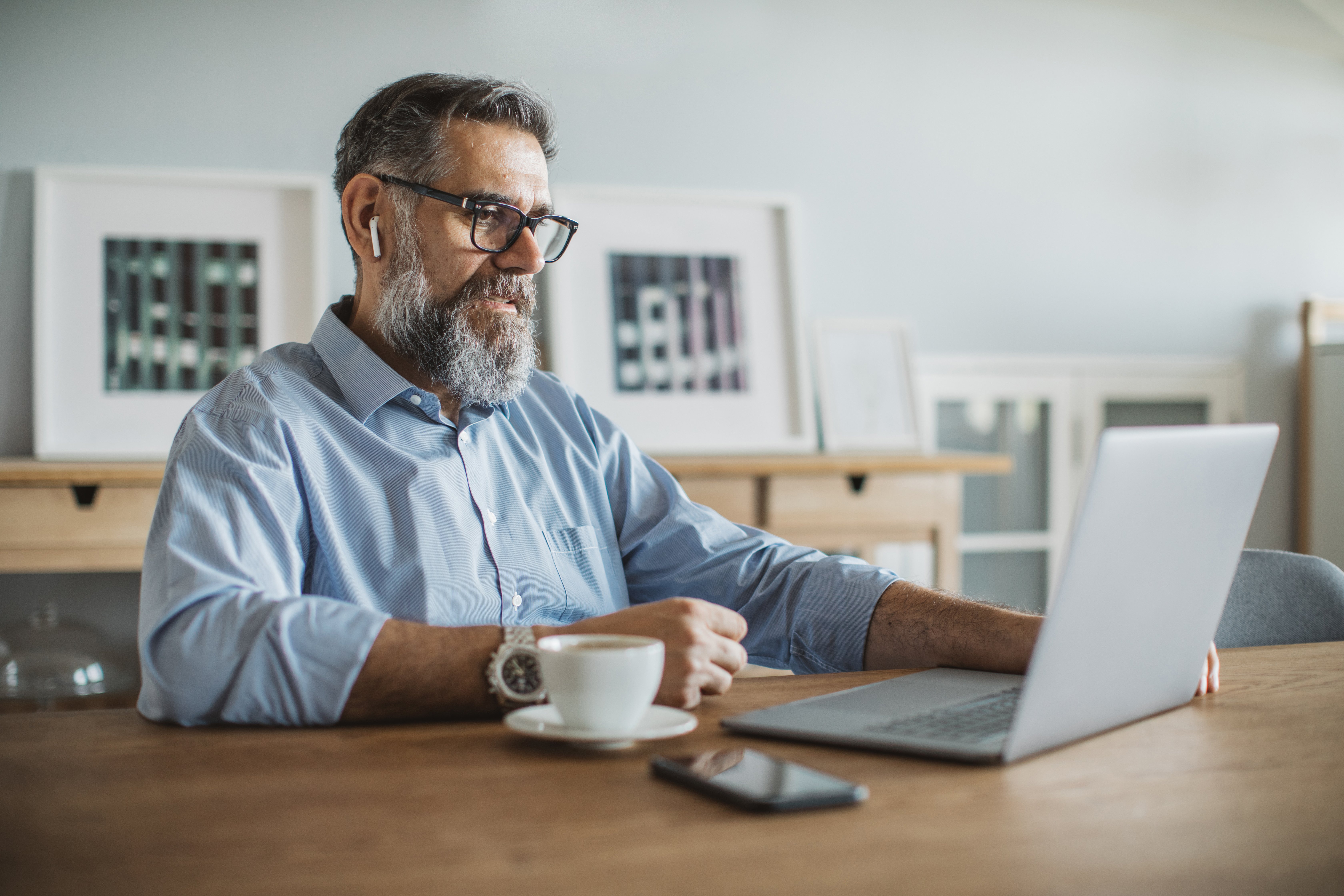 man drinking coffee and on laptop