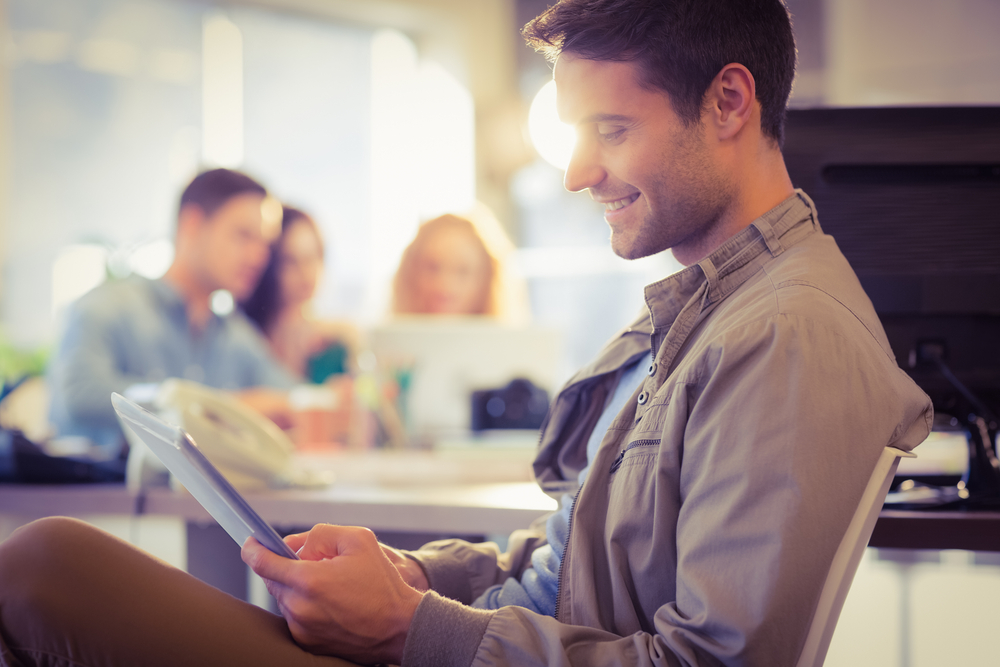 man smiling at tablet