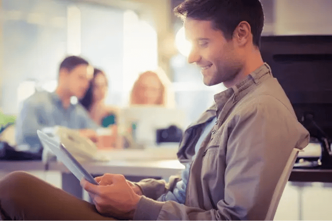 man smiling at tablet