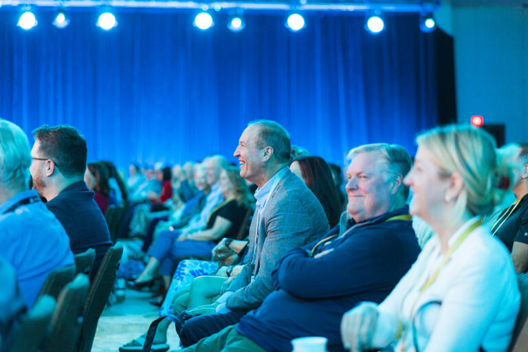 Friendly conference attendees listening to speaker share financial advisor insights